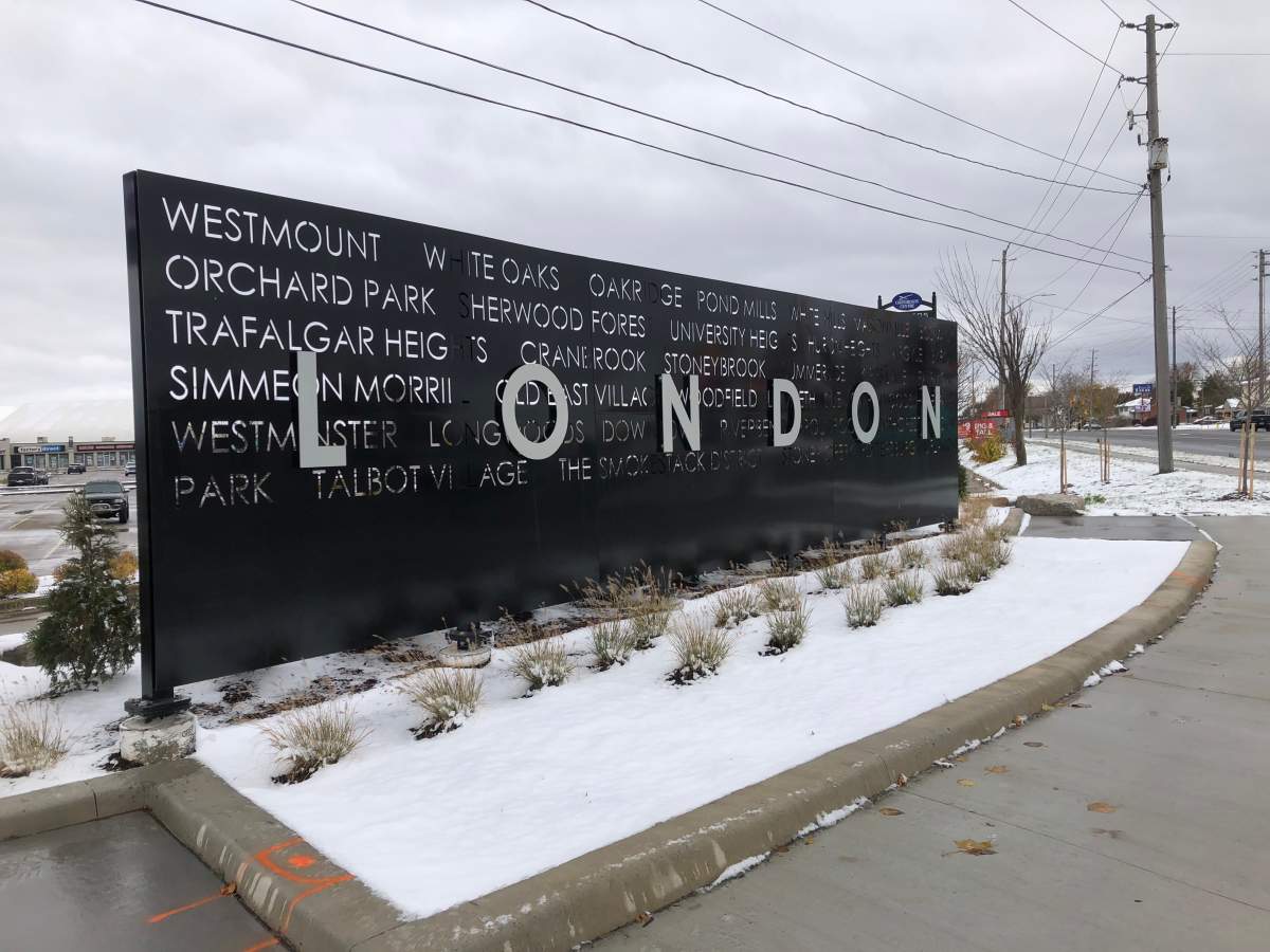 A sign for the City of London with snow on the ground.