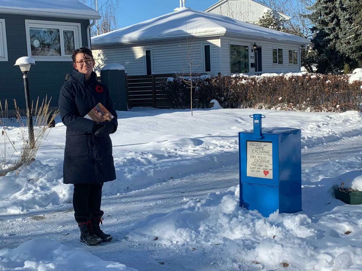 Monique Merchant stands next to her puzzle and game exchange box in the area of 76 Street and 88 Avenue.