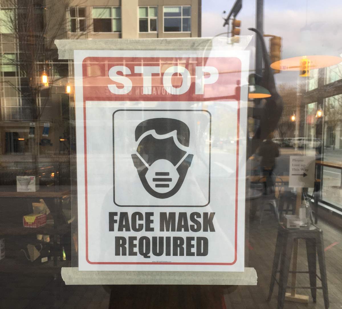 Signage at the coffee shop indicates masks are required.