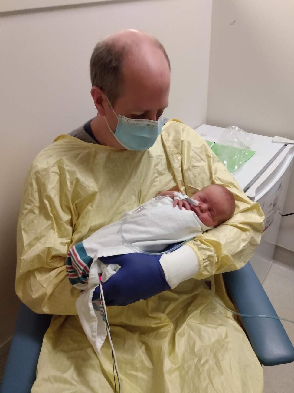 Dave McIntosh holds his newborn son in hospital.