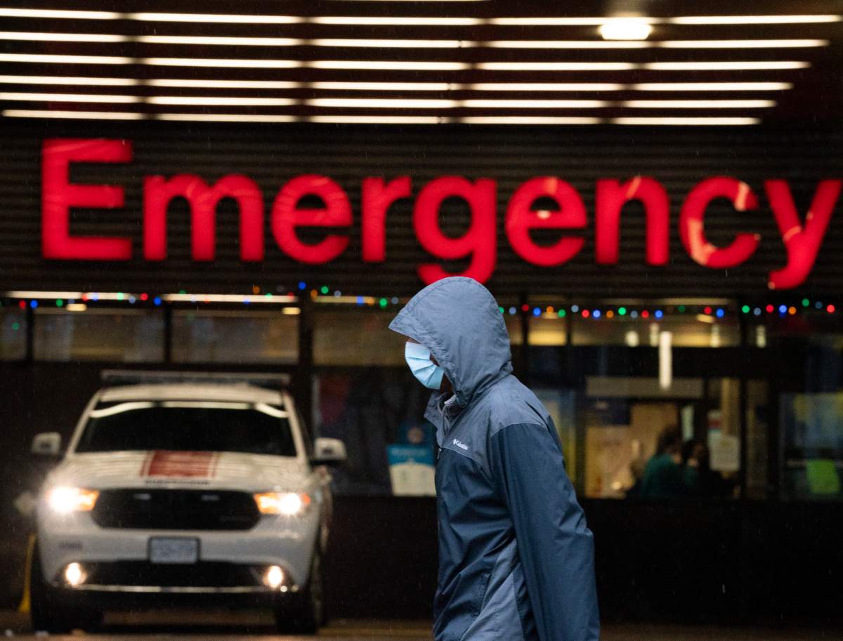 A person wears a protective face mask to help prevent the spread of COVID-19 as they walk past the emergency department of the Vancouver General Hospital in Vancouver Wednesday, November 18, 2020.   