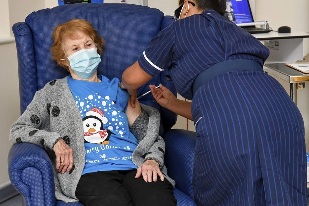 90 year old Margaret Keenan, the first patient in the UK to receive the Pfizer-BioNTech COVID-19 vaccine, administered by nurse May Parsons at University Hospital, Coventry, England, Tuesday Dec. 8, 2020. The United Kingdom, one of the countries hardest hit by the coronavirus, is beginning its vaccination campaign, a key step toward eventually ending the pandemic. 
