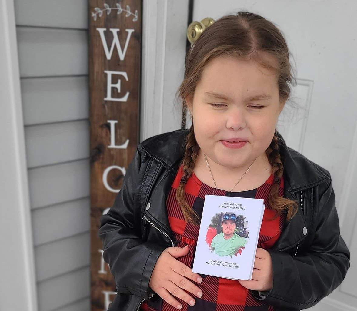 Maddy holds a picture of John Rae, her organ donor.