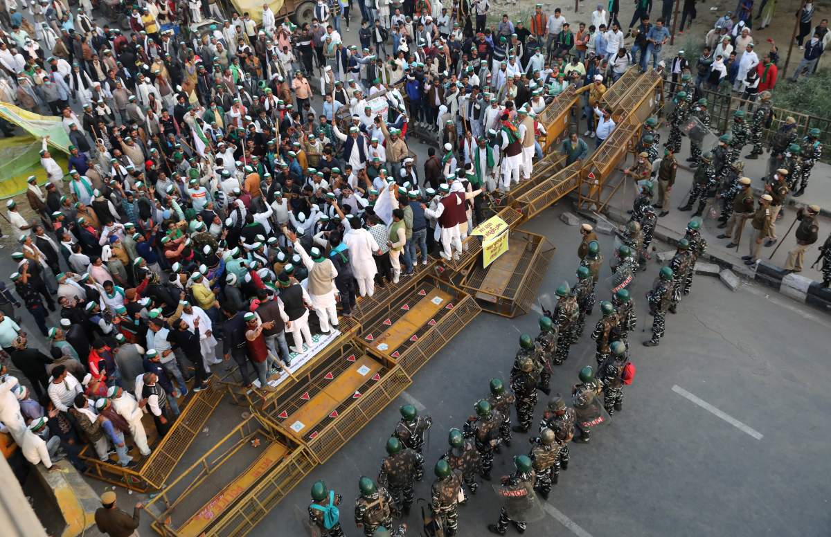 Farmers try to break police barricade during a protest as police stop them from entering Delhi to protest against new farm laws at Delhi-Uttar Pradesh border, India, Dec. 3, 2020.