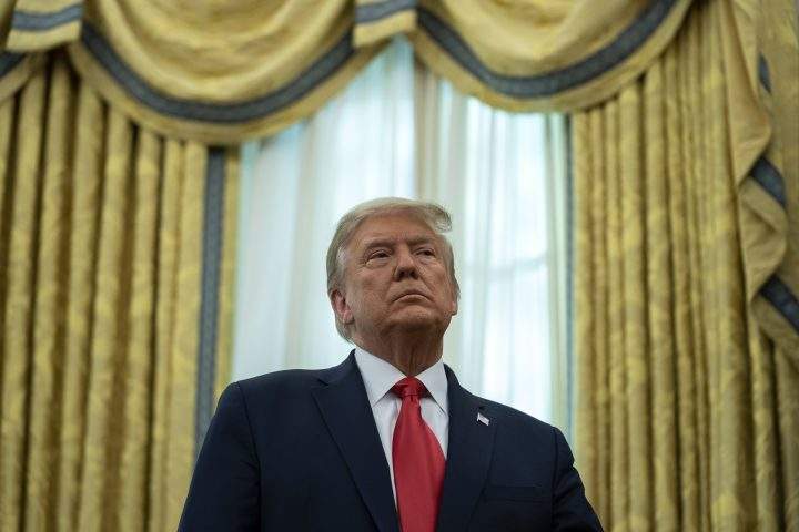 FILE: U.S. President Donald Trump listens during a ceremony to present the Presidential Medal of Freedom to former football coach Lou Holtz, in the Oval Office of the White House, Thursday, Dec. 3, 2020, in Washington.