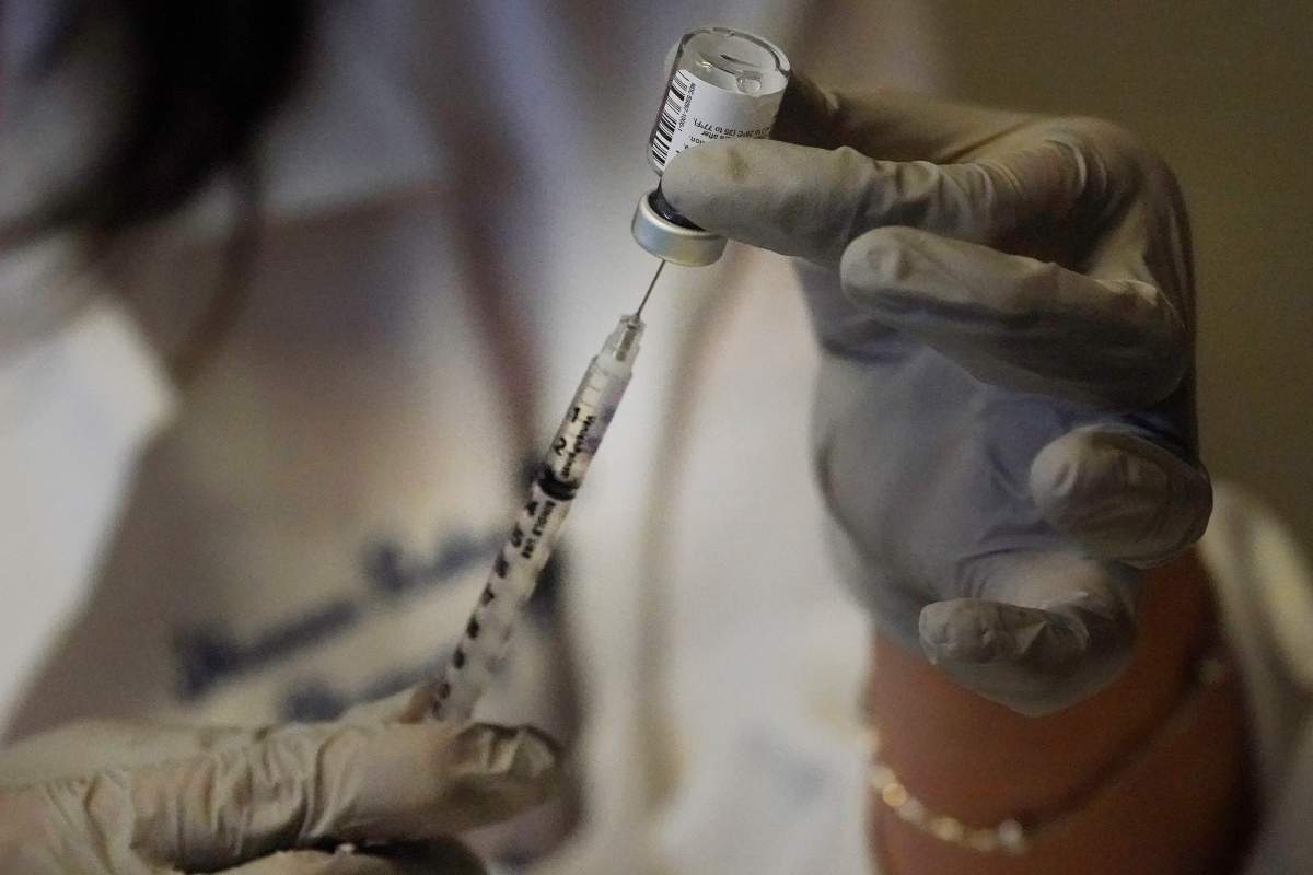 Pharmacy Manager Shannon Baker prepares a syringe for the new COVID-19 vaccine to be administered to a Lifespan Health Care worker, Monday, Dec. 14, 2020, in Providence, R.I.
