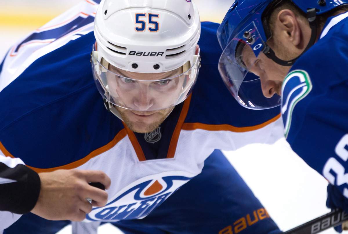 Edmonton Oilers' Mark Letestu, left, and Vancouver Canucks' Henrik Sedin, of Sweden, wait for the puck to be dropped for a faceoff during the first period of a pre-season NHL hockey game in Vancouver, B.C., on Saturday October 3, 2015. THE CANADIAN PRESS/Darryl Dyck.