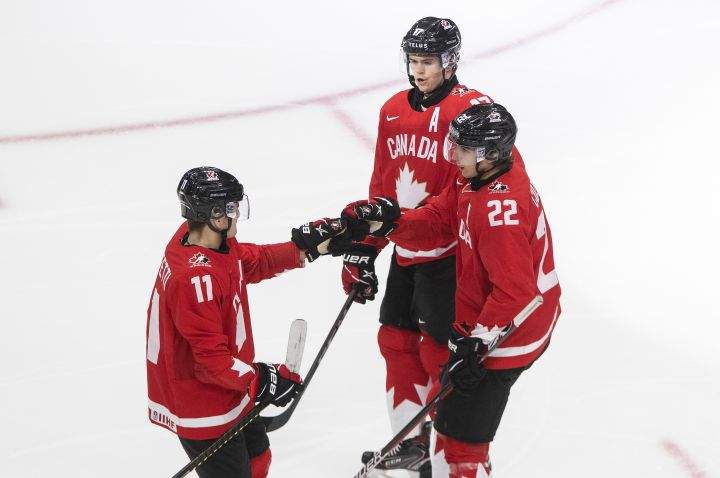 Canada's Cole Perfetti (11), Dylan Cozens (22) and Connor McMichael (17) celebrate a goal against Switzerland during second period IIHF World Junior Hockey Championship action in Edmonton on Tuesday, December 29, 2020. 