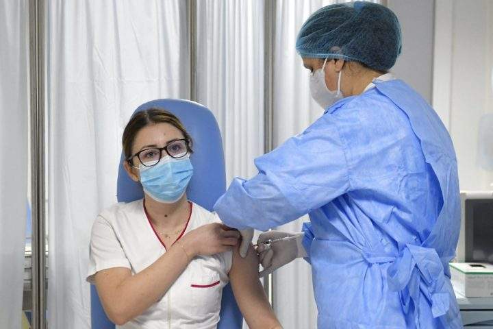 Mihaela Anghel, a Romanian nurse, gets the first COVID-19 vaccine administered in the country in Bucharest, Romania, Sunday, Dec. 27, 2020. Anghel is the nurse who registered and processed Romania's first official COVID-19 patient, on Feb. 27, 2020.