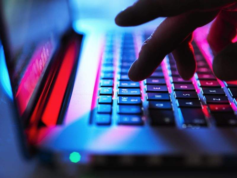 FILE: Man typing at his laptop computer at night.