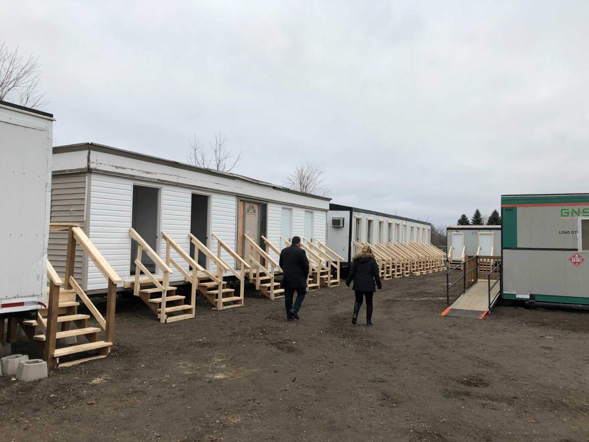 Craig Cooper (left) and Debbie Kramers, a pair of city managers tasked with homeless prevention, walk through 652 Elizabeth St. as the site gets ready to house unsheltered individuals over the winter.