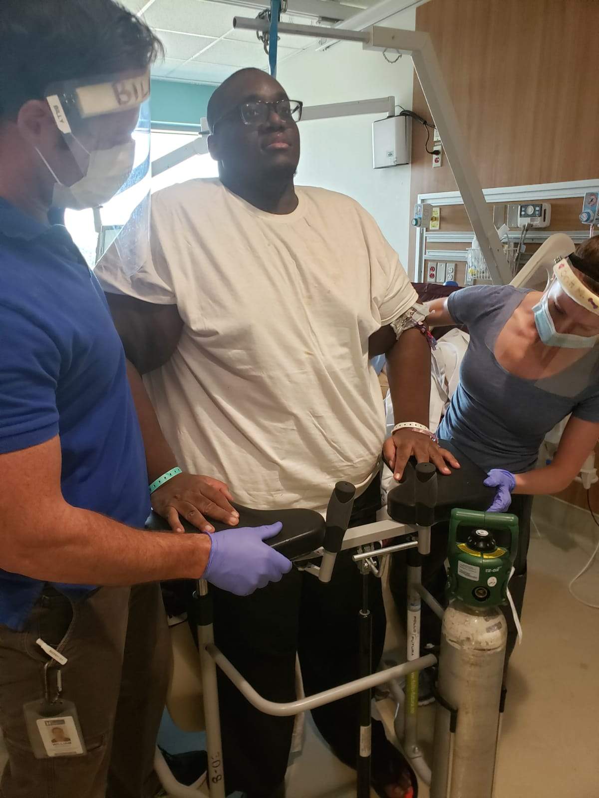 Delroy Noble stands up for the first time after spending two months on a ventilator with COVID-19.