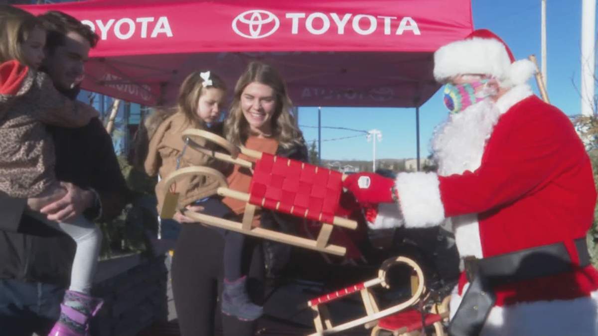 Hundreds of sleds and toys were donated to Calgary kids, including to Lukah Mitchell, seen with her mother Tanis on Sunday, Dec. 20, 2020. 