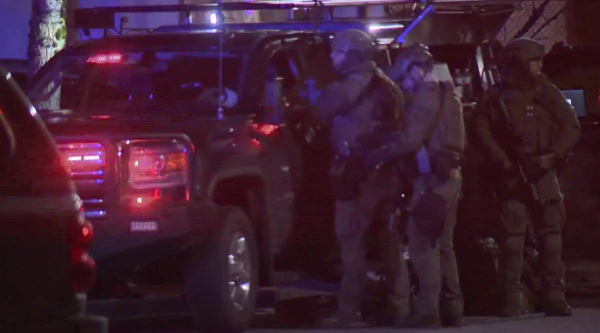 Heavily armed police take their positions outside an Abbotsford home during a tense standoff Thursday evening.