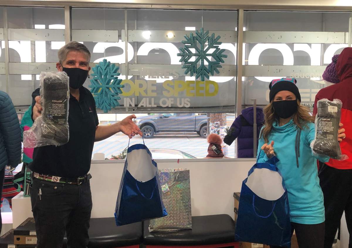 Luke MacDonald (left) accepts a donation of wool socks to Snookie Socks.
