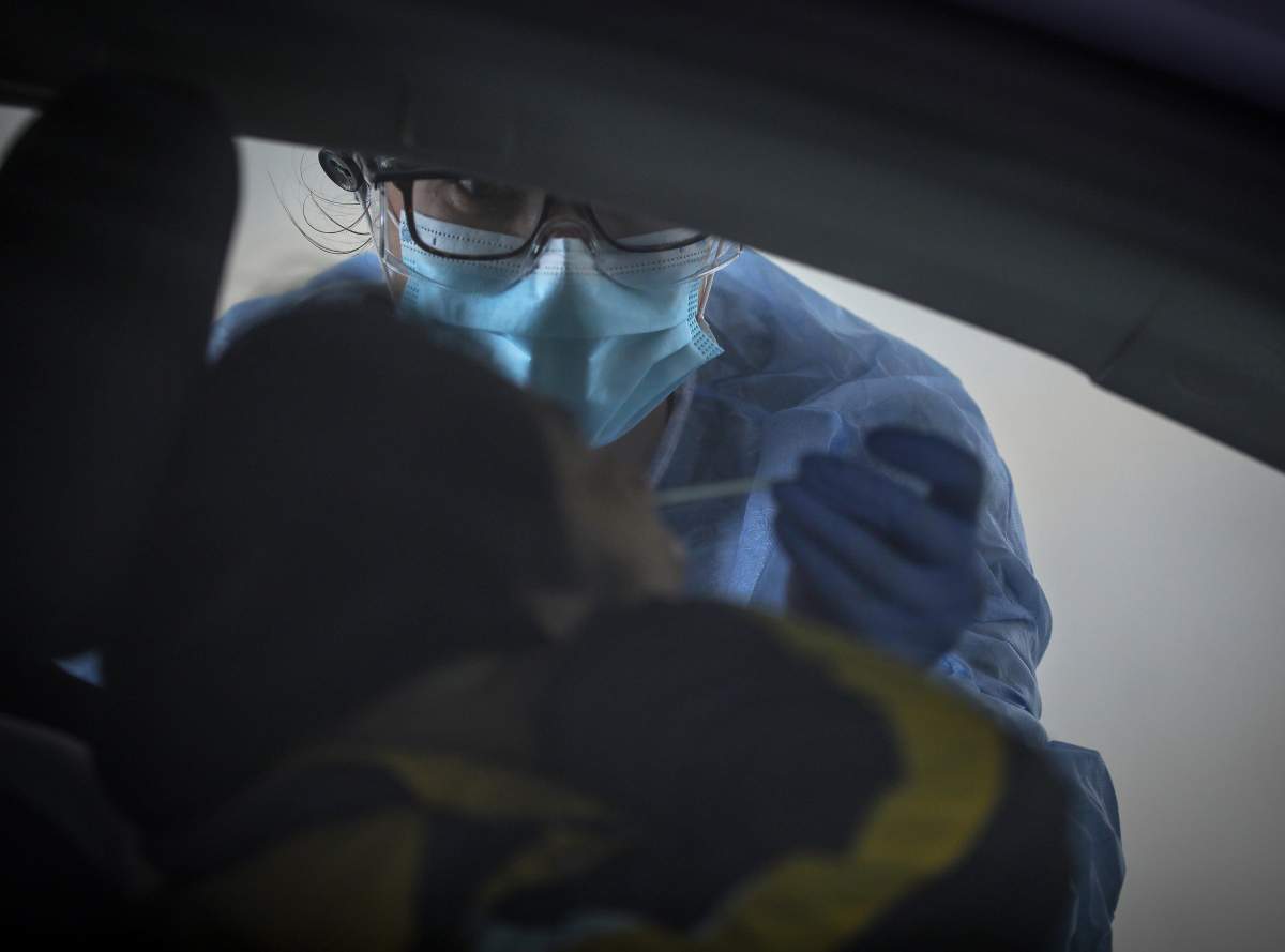An Alberta health-care worker performs a COVID-19 test. 