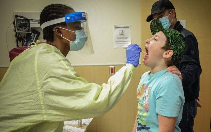 An Alberta Health Services worker swabs a child to test for COVID-19 in this file photo. On Friday Shared Health said "unprecedented" patient volumes seen at the ER at Health Sciences Centre's children's hospital last weekend have dropped, but remain "elevated.".