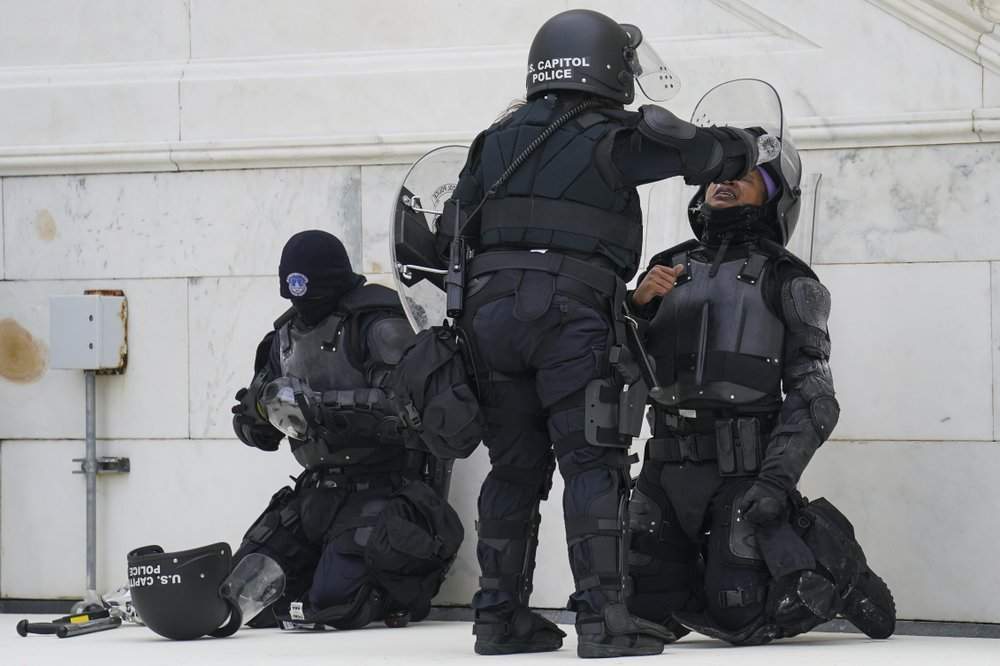 A police officer has eyes flushed with water after a confrontation with demonstrators, Wednesday, Jan. 6, 2021, at the Capitol in Washington.