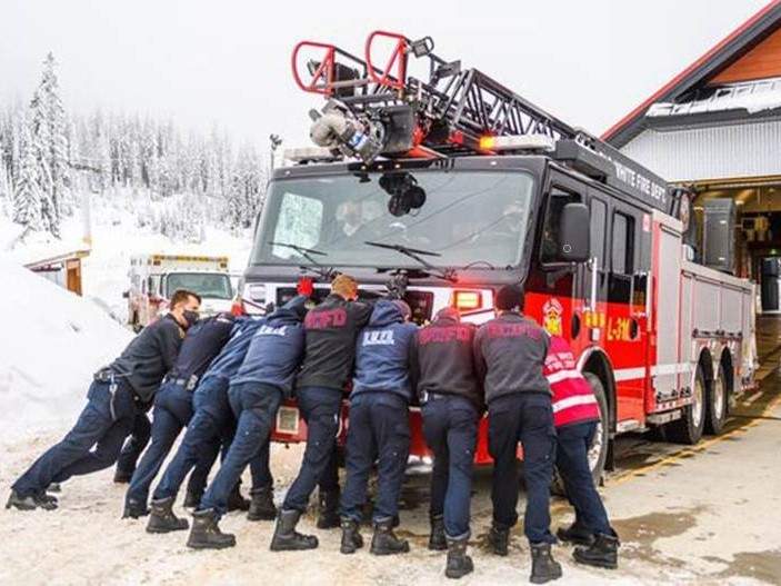 Big White firefighters followed a century-long tradition of using human power to push their new ladder truck into its fire station bay. 