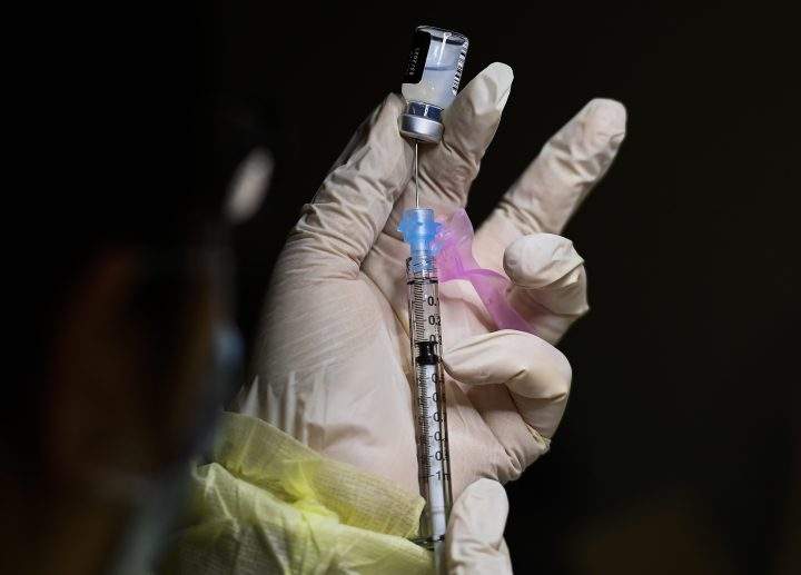 A registered pharmacist technician carefully fills the Pfizer-BioNTech COVID-19 mRNA vaccine at a vaccine clinic during the COVID-19 pandemic in Toronto on Tuesday, Dec. 15, 2020.