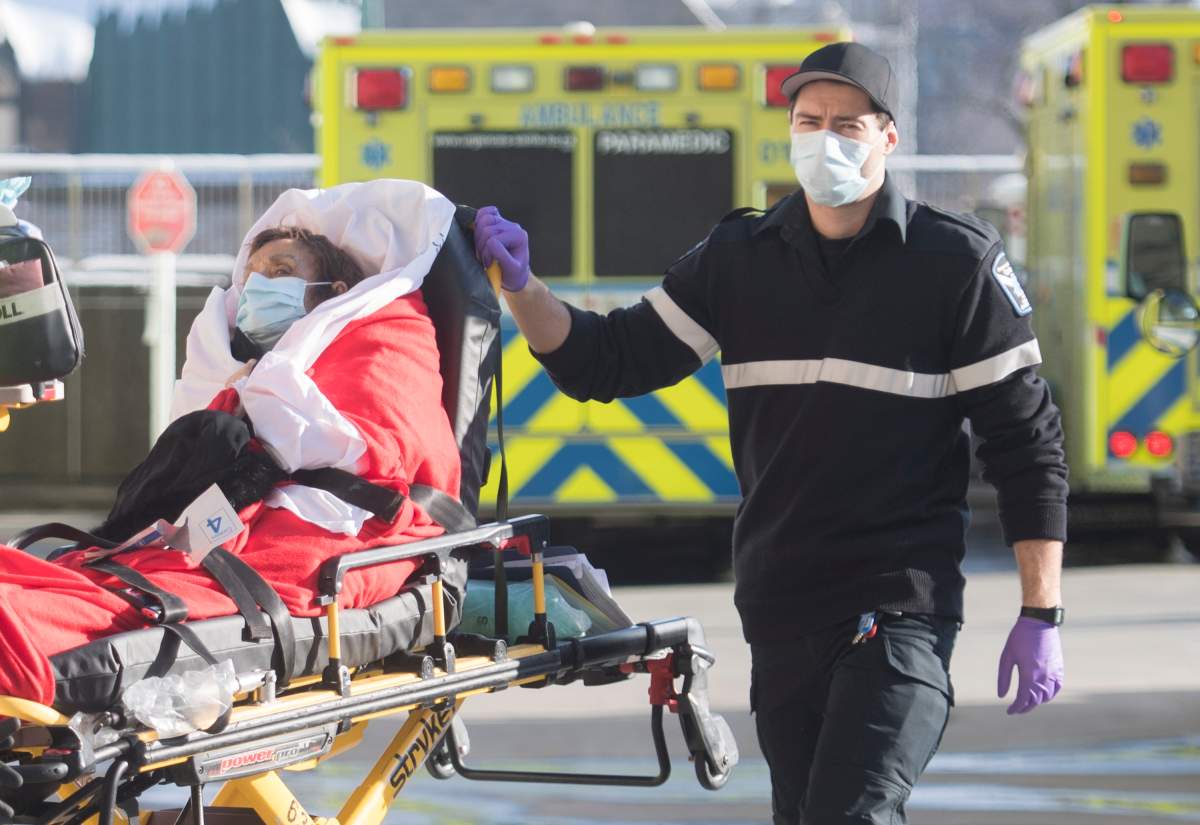A paramedic transfers a woman from an ambulance into a hospital in Montreal, Saturday, Jan. 2, 2021, as the COVID-19 pandemic continues in Canada and around the world. 