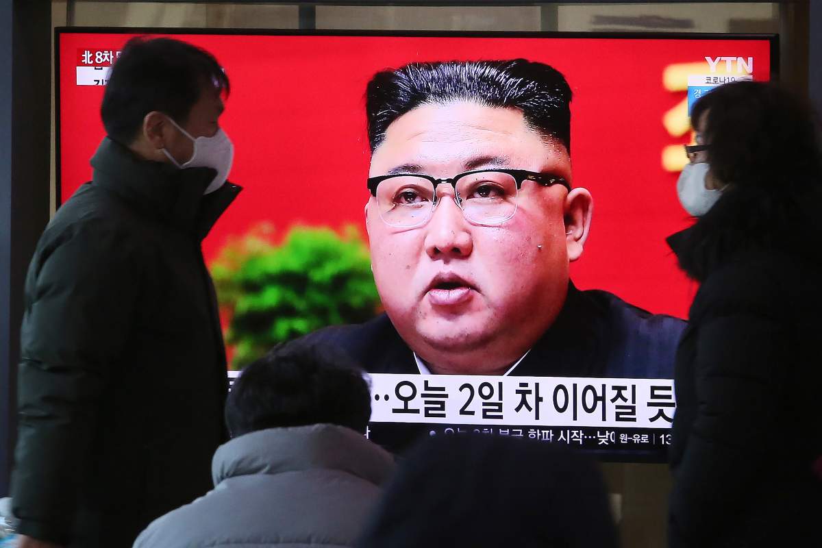 People walk by a TV screen showing North Korean leader Kim Jong Un during a ruling party congress, at the Seoul Railway Station in Seoul, South Korea, Wednesday, Jan. 6, 2021.