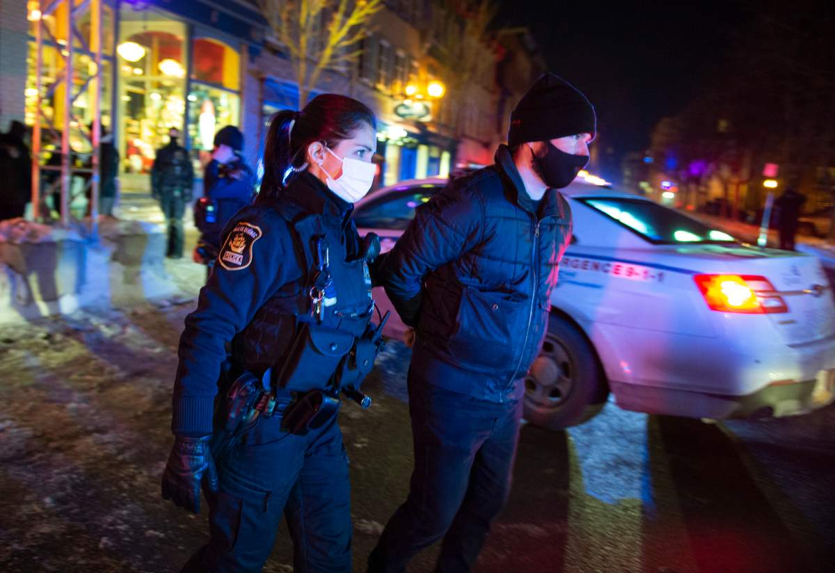 A man is arrested by police after 8 p.m. as a curfew begins in the province of Quebec to counter the spread of COVID-19 on Saturday, January 9, 2021 in Quebec City. A handful of demonstrators walked downtown to protest the curfew.