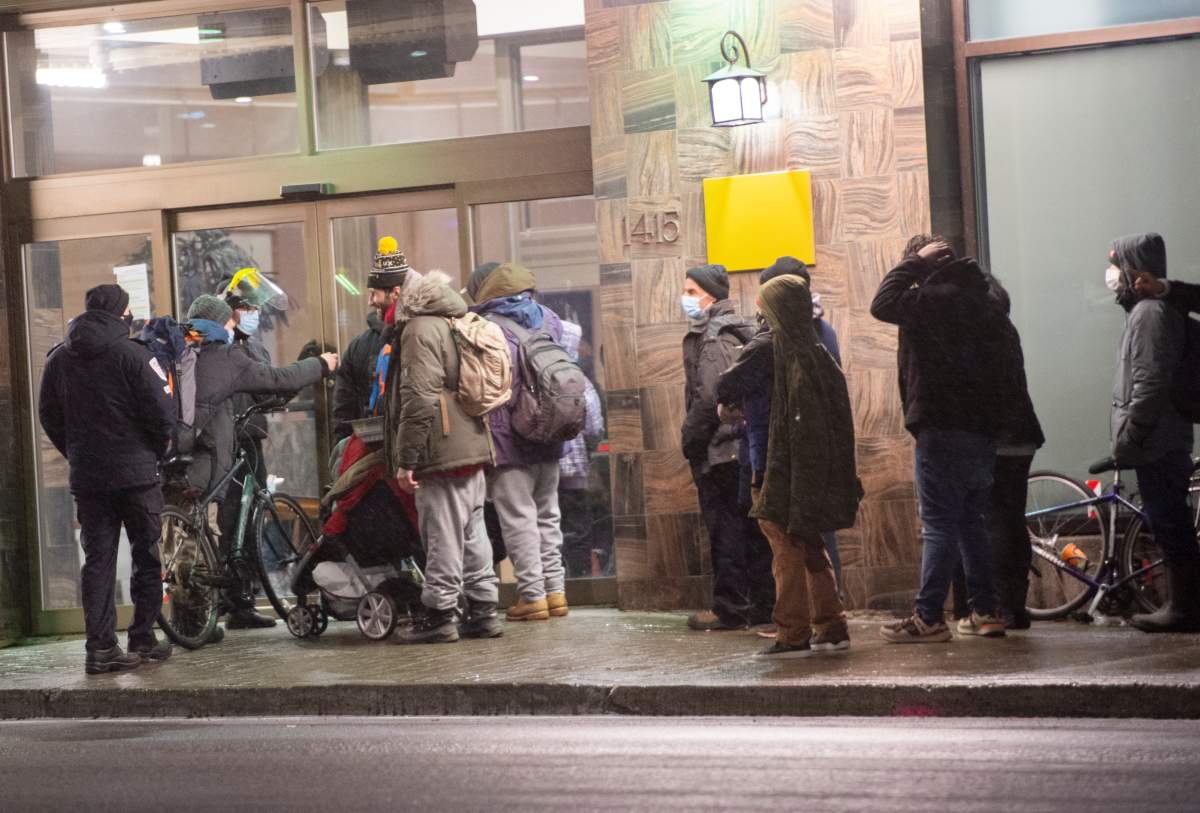 People line-up at a hotel for the homeless before the 8 p.m.   COVID-19 curfew Monday, January 11, 2021 in Montreal. 