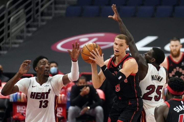 Toronto Raptors guard Malachi Flynn (8) goes up for a shot between Miami Heat center Bam Adebayo (13) and guard Kendrick Nunn (25) during the first half of an NBA basketball game Friday, Jan. 22, 2021, in Tampa, Fla.