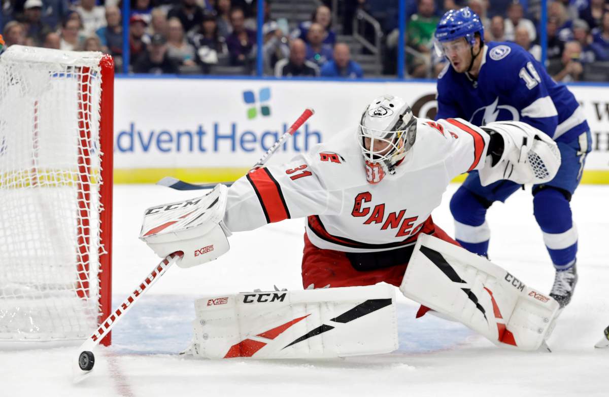 Carolina Hurricanes goaltender Anton Forsberg (31) makes a save on a shot as Tampa Bay Lightning right wing Taylor Raddysh (16) looks for a rebound during the second period of an NHL preseason hockey game Tuesday, Sept. 17, 2019, in Tampa, Fla. (AP Photo/Chris O'Meara).