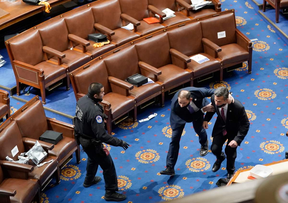 Members of congress run for cover as protesters try to enter the House Chamber during a joint session of Congress on January 06, 2021 in Washington, DC. – Drew Angerer/Getty Images