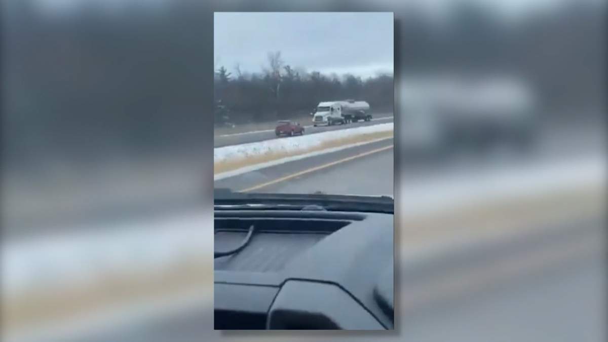 Small red car travelling westbound in the eastbound lanes near Belleville