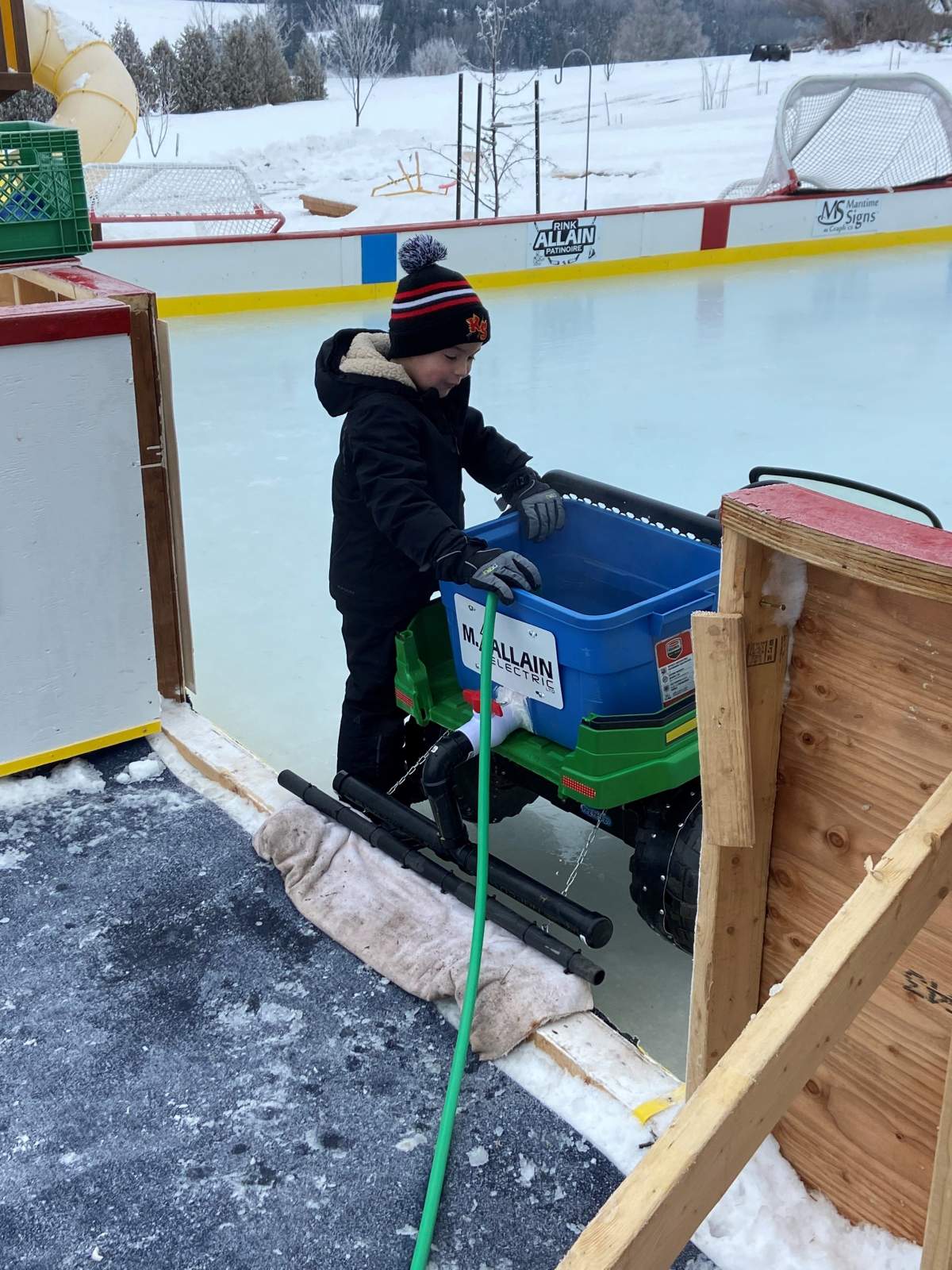 Five-year-old Nicholas Allain is seen getting ready to clear the ice in his min-Zamboni.