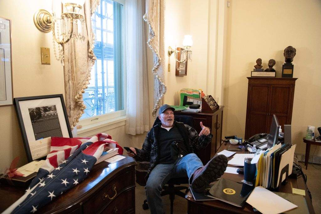 Richard Barnett, a supporter of U.S. President Donald Trump, sits inside the office of U.S. Speaker of the House Nancy Pelosi as he protests inside the U.S. Capitol in Washington, D.C. on Jan. 6, 2021.