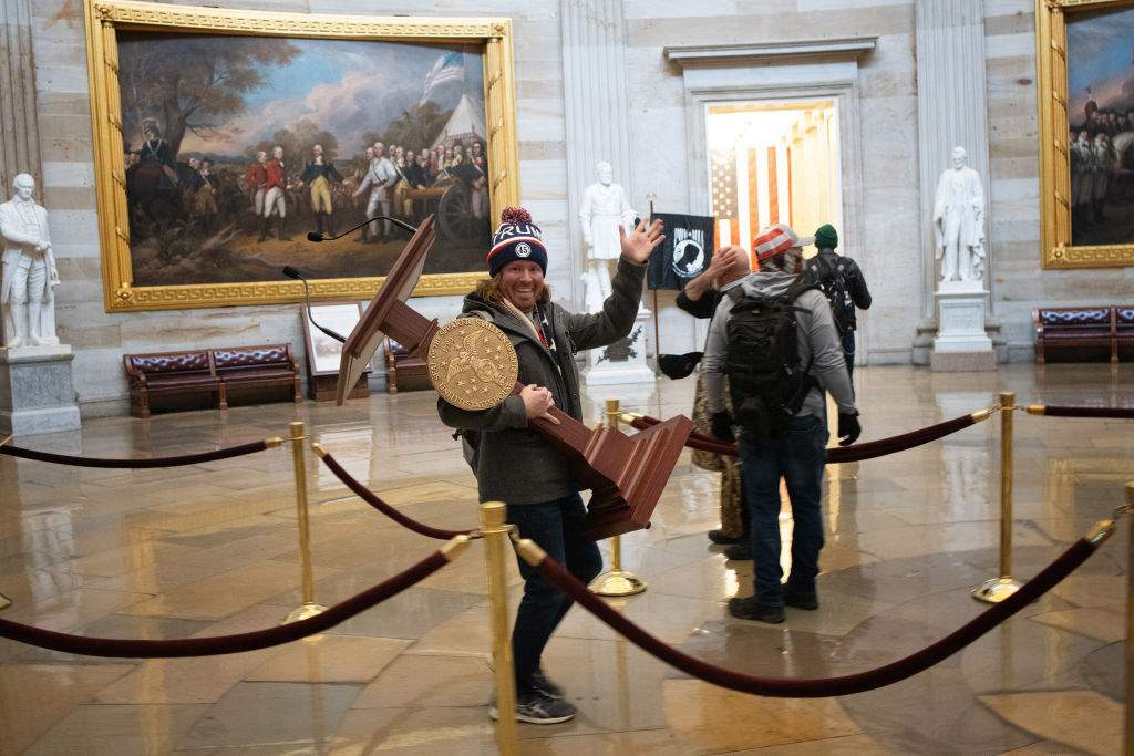 A pro-Trump protester carries the lectern of U.S. Speaker of the House Nancy Pelosi through the Rotunda of the U.S. Capitol Building after a pro-Trump mob stormed the building on Jan. 6, 2021, in Washington, D.C.