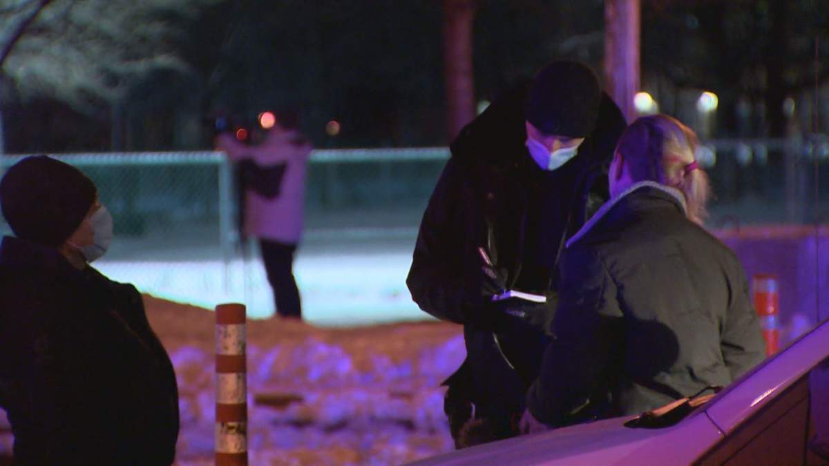 A woman is given a ticket at an anti-curfew protest in Quebec. Jan 9, 2020.