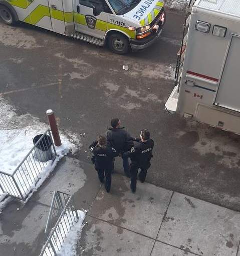 London police lead a man away in handcuffs during a weapons investigation at 345 Wharncliffe Rd. N on Feb. 11, 2021.