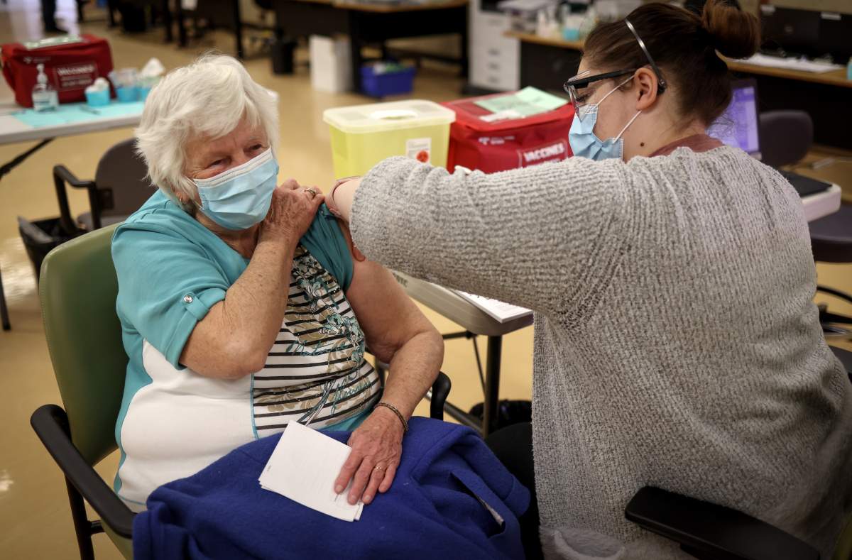 Mary House, 80, receives the COVID-19 vaccine from Alyssa Zaderey in Calgary on Wednesday, Feb. 24, 2021.