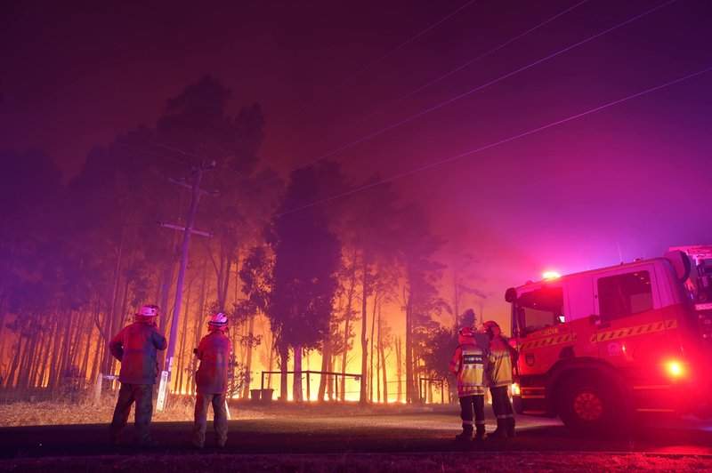 Firefighters attend a fire at Wooroloo, near Perth, Australia, Monday, Feb. 1, 2021. An out-of-control wildfire burning northeast of the Australian west coast city of Perth has destroyed an estimated 30 homes and was threatening more Tuesday, with many locals across the region told it is too late to leave. 