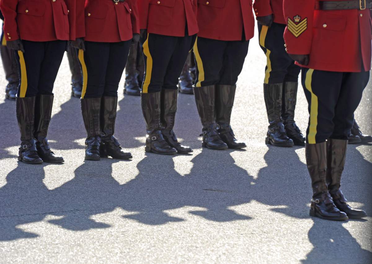 RCMP officers line up before a memorial for fallen mounties at RCMP Depot in Regina, Sask., on Sunday, Sept. 13, 2015. 