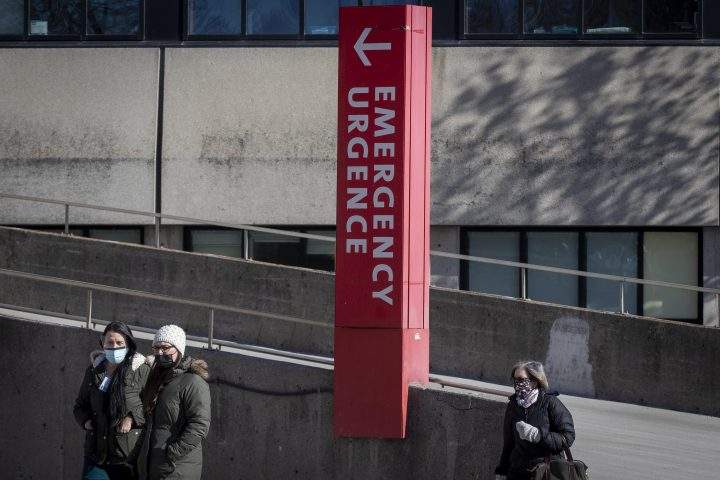 People wear masks to protect them from the COVID-19 virus as they walk past the emergency at Kingston General Hospital (KGH) in Kingston, Ontario on Thursday, February 4, 2021.