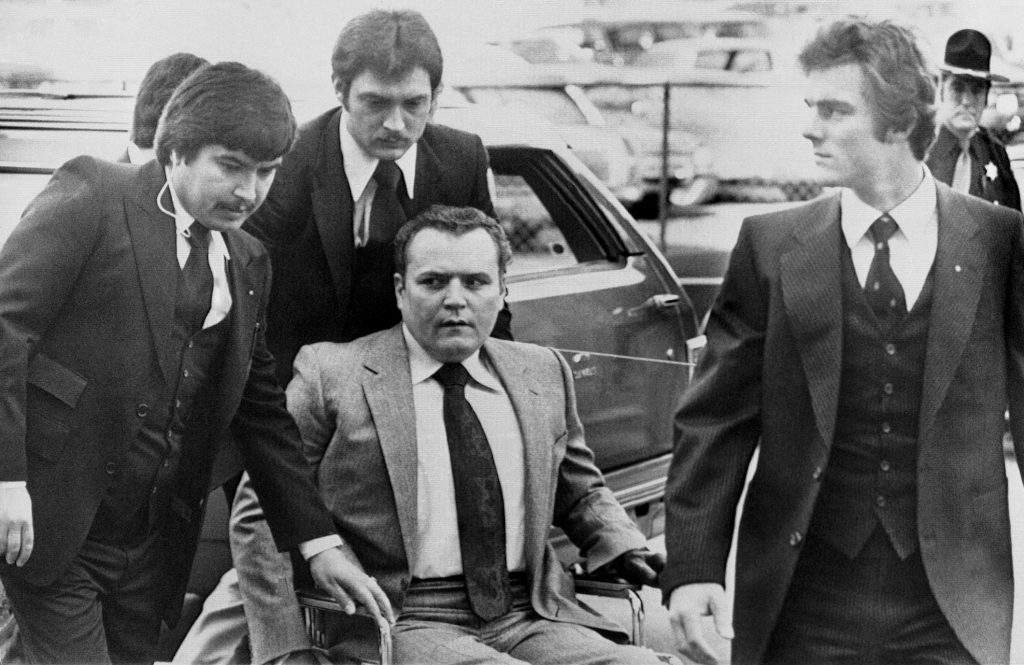 FILE – “Hustler” magazine publisher Larry Flynt is surrounded by heavy security as he arrives at the Fulton County Courthouse in Atlanta on March 19, 1979, for the start of his trial on obscenity charges. Flynt, who turned “Hustler” magazine into an adult entertainment empire while championing First Amendment rights, has died at age 78. His nephew, Jimmy Flynt Jr., told The Associated Press that Flynt died Wednesday, Feb. 10, 2021, of heart failure at his Hollywood Hills home in Los Angeles. (AP Photo/Steve Helber, File)