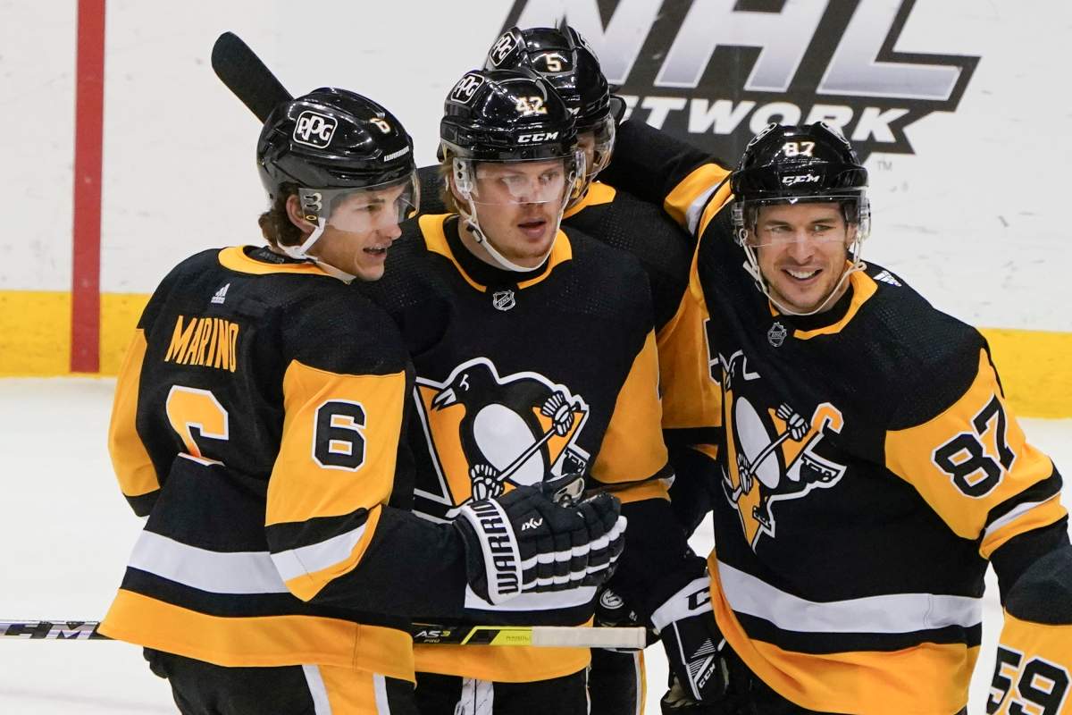 Pittsburgh Penguins’ Sidney Crosby (87) celebrates with Kasperi Kapanen, center, and John Marino (6) after scoring against the New York Islanders during the first period of an NHL hockey game Thursday, Feb. 18, 2021, in Pittsburgh. (AP Photo/Keith Srakocic)