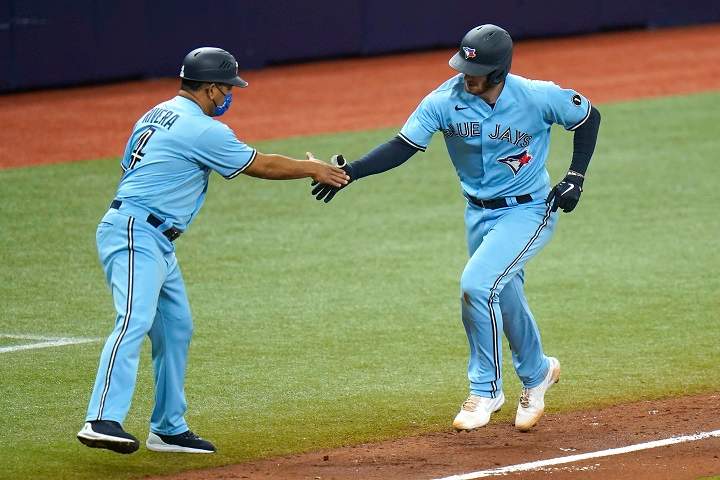 Toronto Blue Jays' Danny Jansen shakes hands with third base coach Luis Rivera (4) after Jensen hit a solo home run off Tampa Bay Rays starting pitcher Tyler Glasnow during the third inning of Game 2 of an American League wild-card baseball series Wednesday, Sept. 30, 2020, in St. Petersburg, Fla.