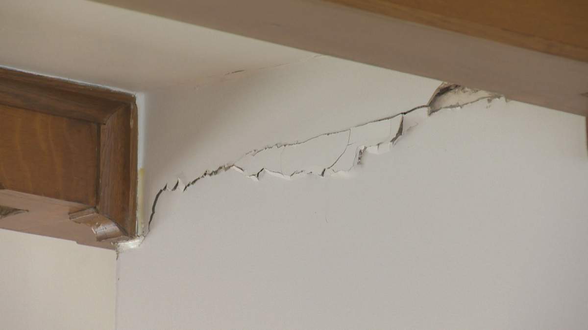 Cracks are seen in the home’s stucco walls.
