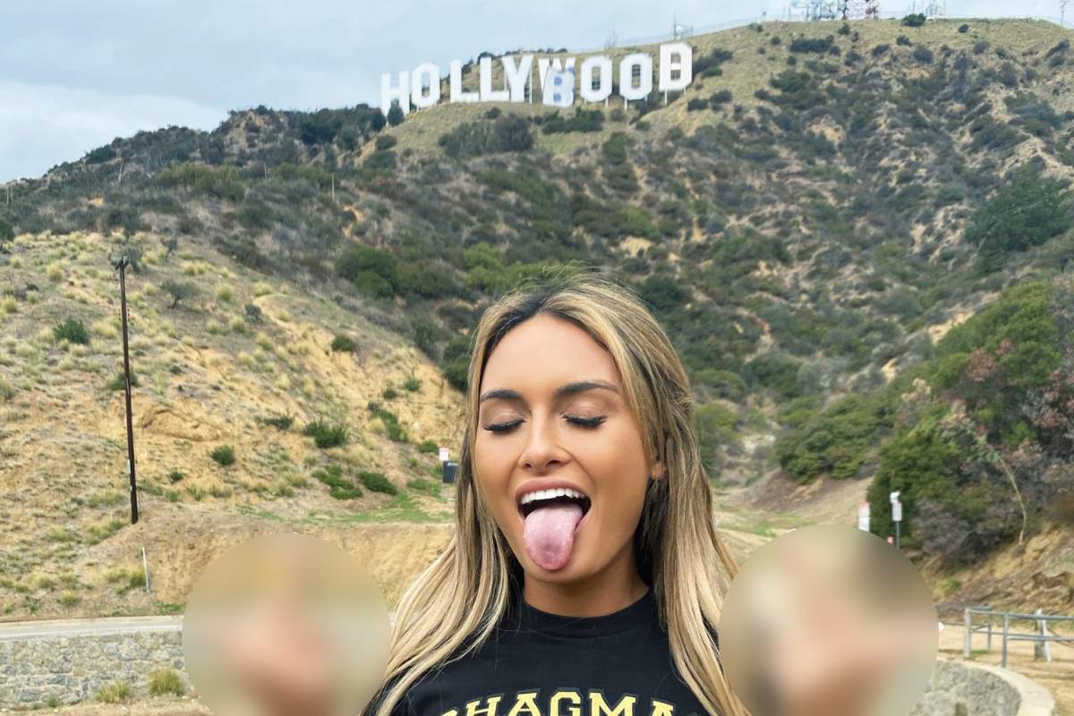 Model Julia Rose poses in front of the Hollywood sign after it was altered in a prank on Feb. 1, 2021, in Los Angeles, Calif.