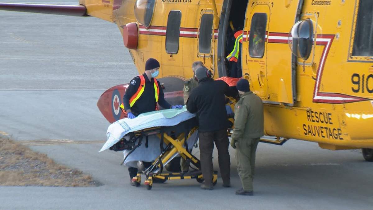 A military search-and-rescue helicopter arrives at an airfield in Squamish after rescuing two men from the backcountry following an avalanche. 