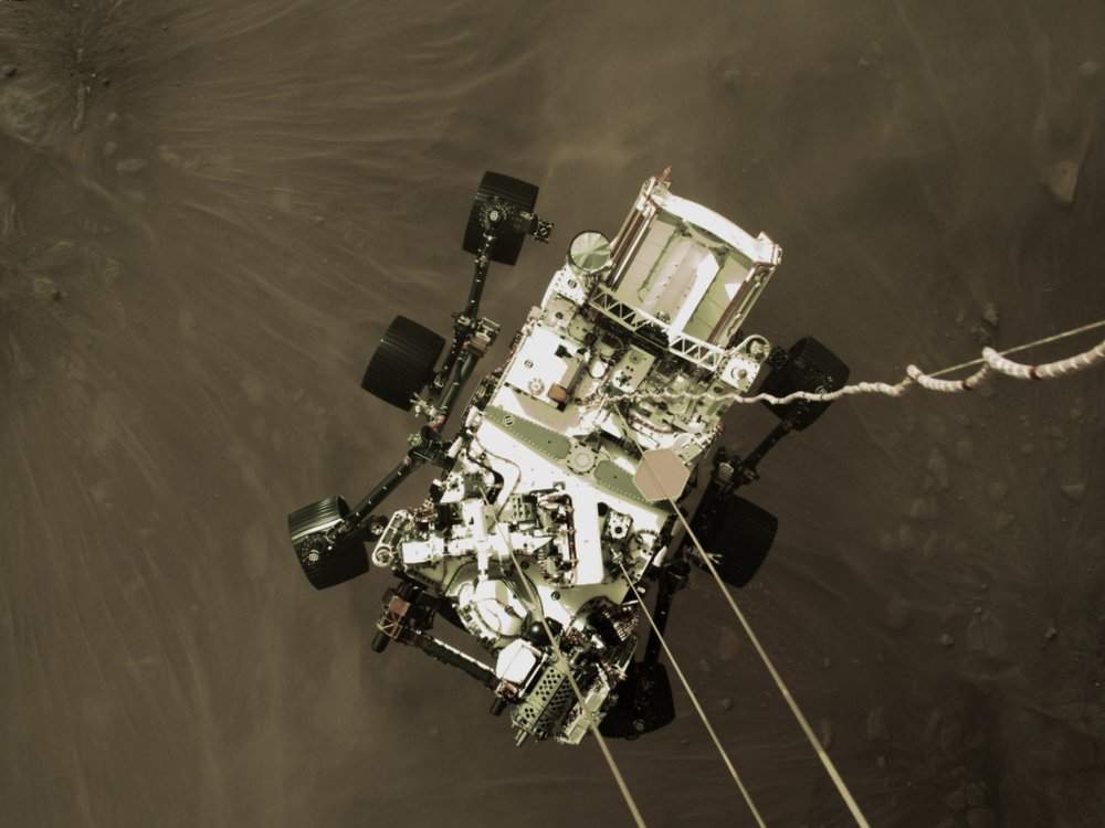 Photo provided by NASA shows the Perseverance rover lowered towards the surface of Mars during its powered descent. (NASA via AP)