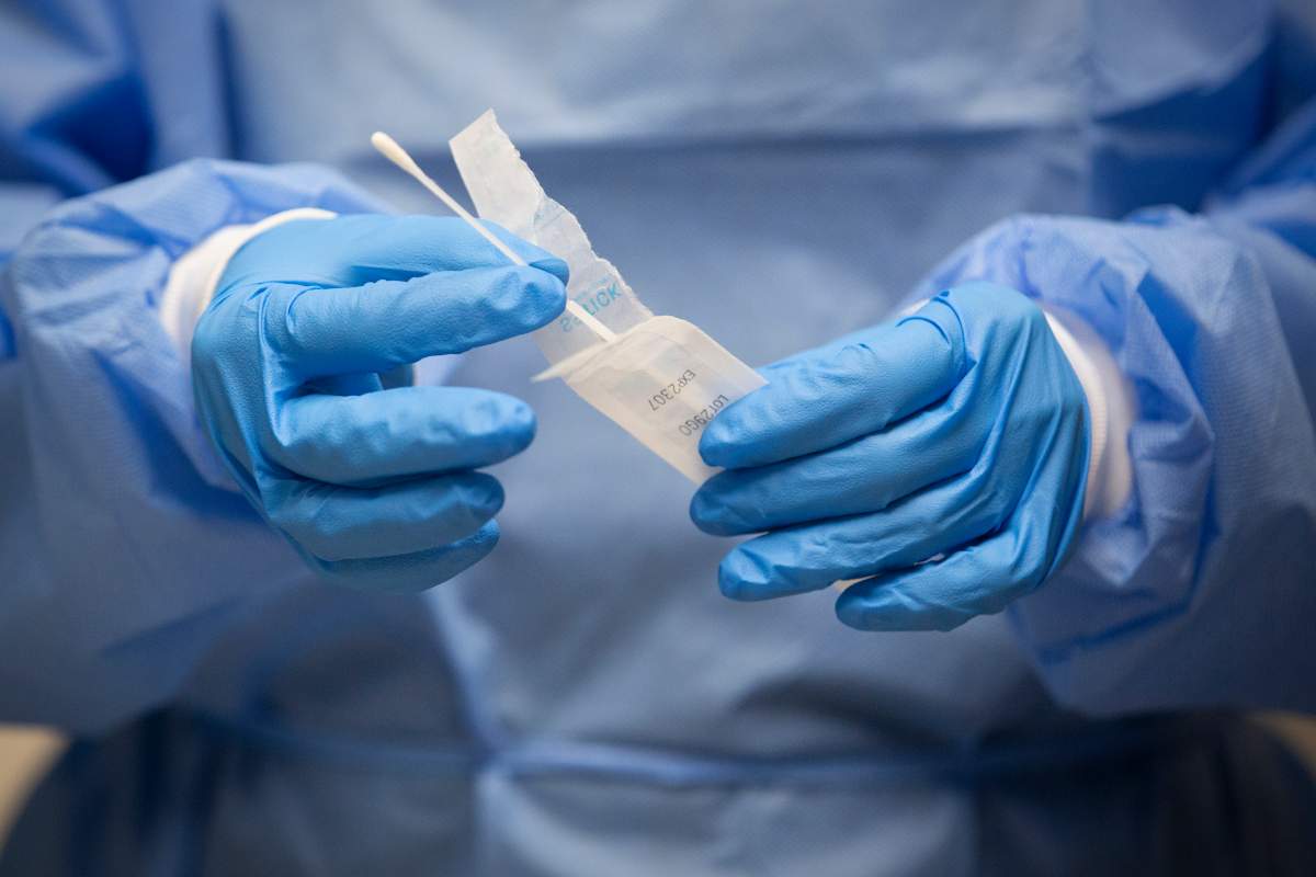 A pharmacist holds a COVID-19 test swab at a pharmacy in Amherstview, Ont., on Friday, Jan. 22, 2021, as the COVID-19 pandemic continues across Canada and around the world.