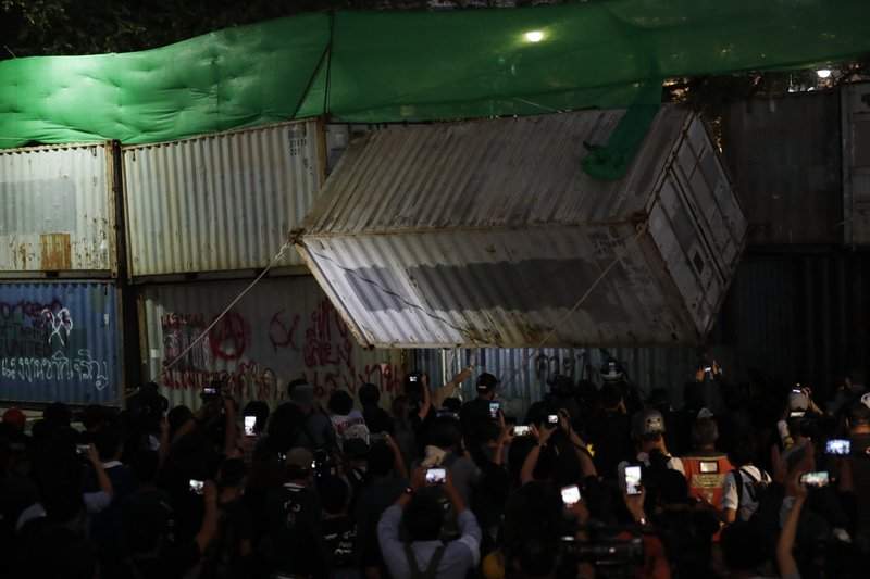Protesters pull down a shipping container used as a barricade in front of the Grand Palace Saturday, March 20, 2021, in Bangkok, Thailand. Thailand's student-led pro-democracy movement is holding a rally in the Thai capital, seeking to press demands that include freedom for their leaders, who are being held without bail on charges of defaming the monarchy. 